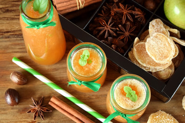Apple beverage with candied ginger and different spices in glass jars