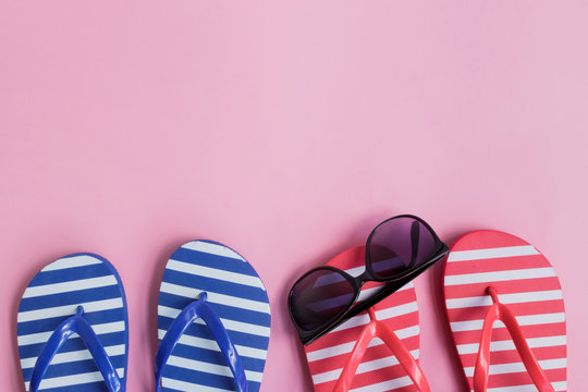 Flip flops and sunglasses on a pink background