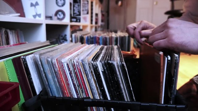 Man looking at old vinyl records at flea market.