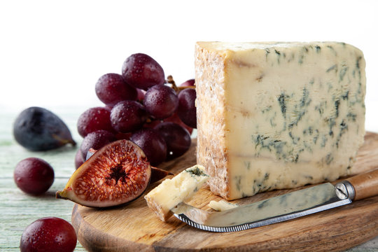 Stilton On A Cheese Board With Red Grapes, Fig And Cheese Knife