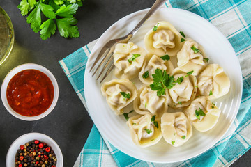 Homemade ready dumplings on a gray concrete table.