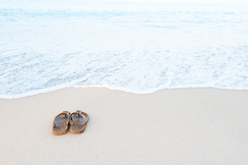 Brown male sandals on tropical sea and beach.