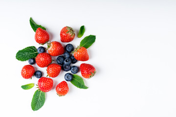 Fresh berries on white background, top view. Strawberry, blueberry and mint leaf, flat lay