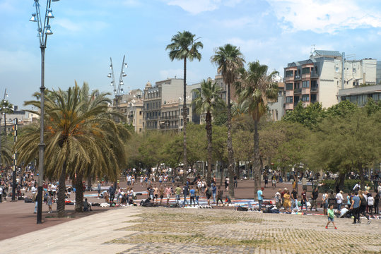 Gente paseando por el puerto viejo de Barcelona