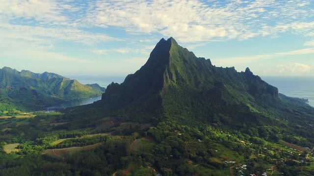 Aerial view of Mount Rotui, lush green jungle, picturesque hills, mountains, valleys and bays - Moorea island, South Pacific Ocean, French Polynesia landscape from above, 4k