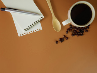 Flat lay brown desk with notebook and a cup of coffee  with copy space
