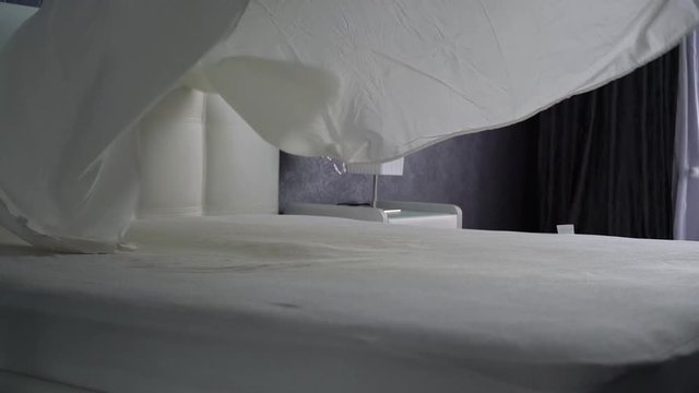 Covers the sheets on a white bed. White fabric is thrown up and smoothly lays down
