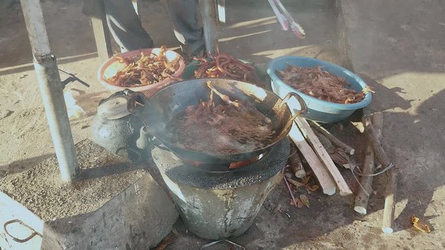 Bullfrogs plunged into boiling oil for cooking. Deep-fried frogs and water snakes inside plastic basins on the side