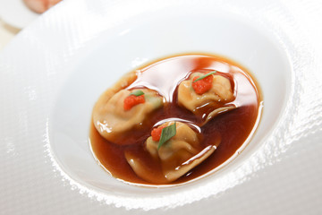 a plate of three pieces of meat in a sauce in restaurant for gourmet