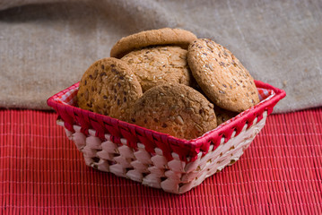 Savory cookies sprinkled with sesame seeds, sunflower on table and burlap background