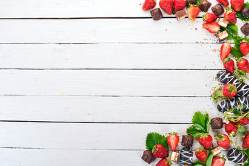 Strawberries with sweets. On a white wooden background. Top view. Copy space.