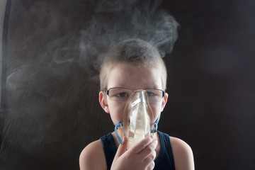 Caucasian blonde boy inhales couples containing medication to stop coughing. Medical procedures....
