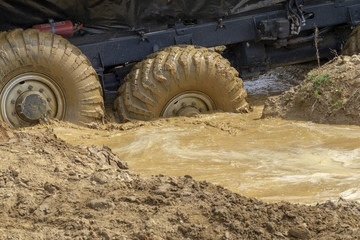big wheels in the mud. The large wheels of a truck stuck in the mud.
