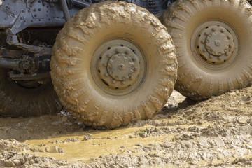 big wheels in the mud. The large wheels of a truck stuck in the mud.