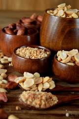 Whole and shredded peanuts in wooden bowls