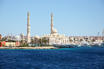 Fototapeta na wymiar Seascape with ships in the seaport and with a mosque in the background. Hurghada, Egypt