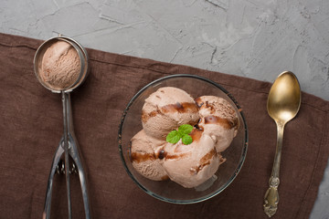 Flatlay with chocolate ice cream and mint and spoon for ice cream. In dark colors, with an empty space for the inscription