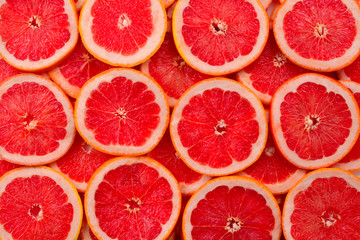Grapefruit red juicy slices background. top view