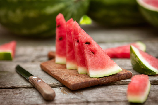 Watermelon slices on chopping board with knife