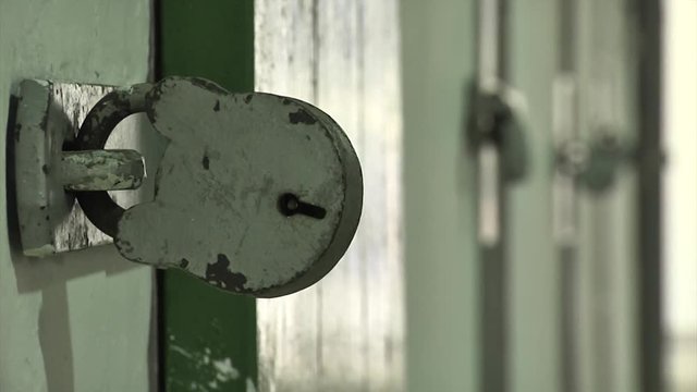Close up rack focus across a large padlocks on prison cell or mental asylum facility doors