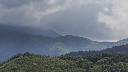 Green mountains landscape with many clouds on a storm rainy forest landscape