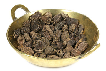 black cardamom in a brass bowl isolated on white background