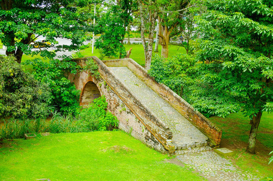Outdoor view of brick bridge located inside the forest in colonial city Popayan