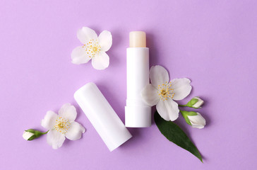 lip balm and flowers on a colored background. minimalism, the top
