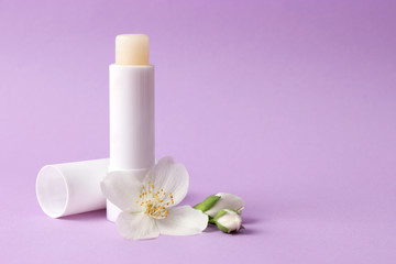 Obraz na płótnie Canvas lip balm and flowers on a colored background. minimalism, the top