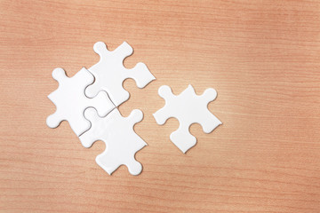 White jigsaws puzzle missing one piece on wood background, Connect and Complete concept
