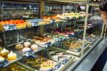 woman choose sweets in store. deserts shop