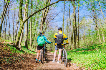 Obraz premium couple stand in forest with bicycles. sport life concept