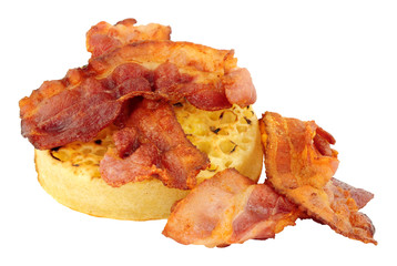 Crispy streaky bacon rashers on a English crumpet isolated on a white background