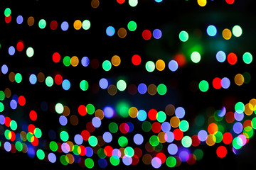 Abstract blurred background with rows of round, radiant multicolored lights.