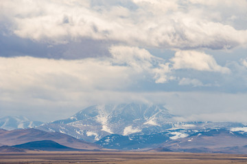 incredible landscape of the peaks of Altai mountains on the background of floating clouds