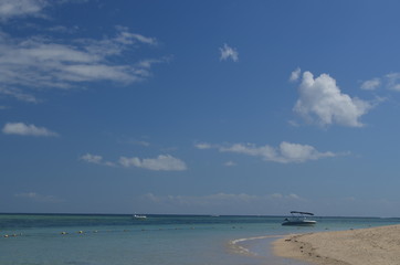 A blue sky over a white beach with turquoise water