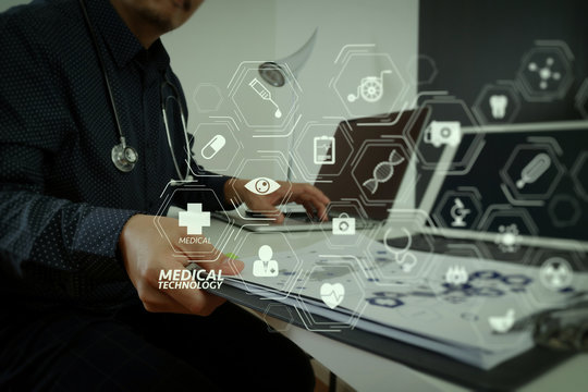 smart medical doctor working with smart phone and digital tablet and laptop computer and stethoscope on wood desk in modern office