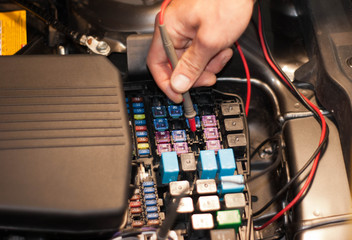 Technicain checking car fuse by lamp tester which nagative pole of lamp tester connected with car...