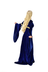 full length portrait of pretty blonde lady wearing  a blue fantasy medieval gown. standing pose on white background.