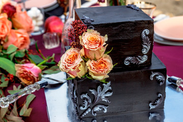 Black wedding cake with natural roses
