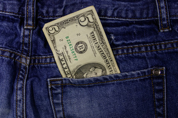 Five dollars banknote in the pocket of blue jeans