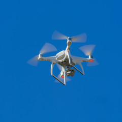 White flying copter against the sky