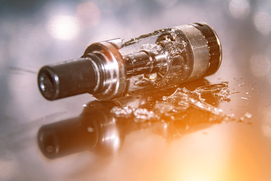 Broken vaping on the table with small pieces of glass. broken glass tank