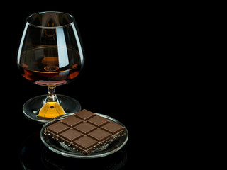 Cognac and chocolate in a glass saucer