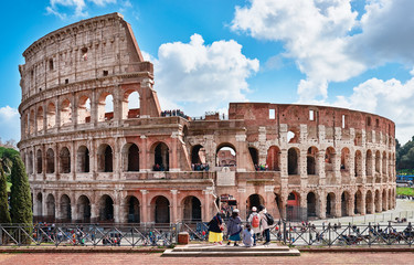Fototapeta na wymiar Colosseum seen from the archaeological site square Francesca Romana, tourists admire the Colosseum