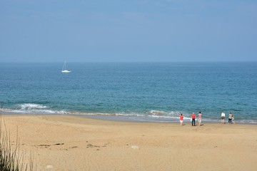 Fototapeta premium Une famille qui se promène sur une plage de Bretagne