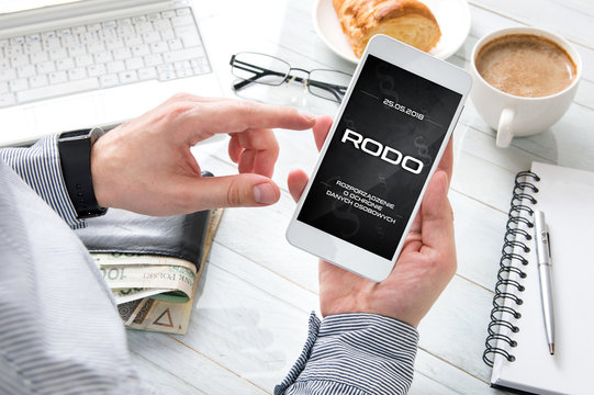Man has "RODO" message on his smartphone and laptop display. Conception of  General Data Protection Regulation in polish law. Interface created in graphic program