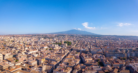 Beautiful aerial view of the Catania city on Sicily from above with Etna volcano visible on the horizon. - obrazy, fototapety, plakaty
