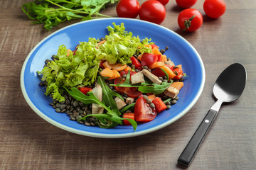 Plate with tasty lentil dish on table