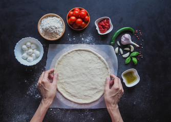 Making dough by female hands at bakery.  Making Italian pizza Margarita. 